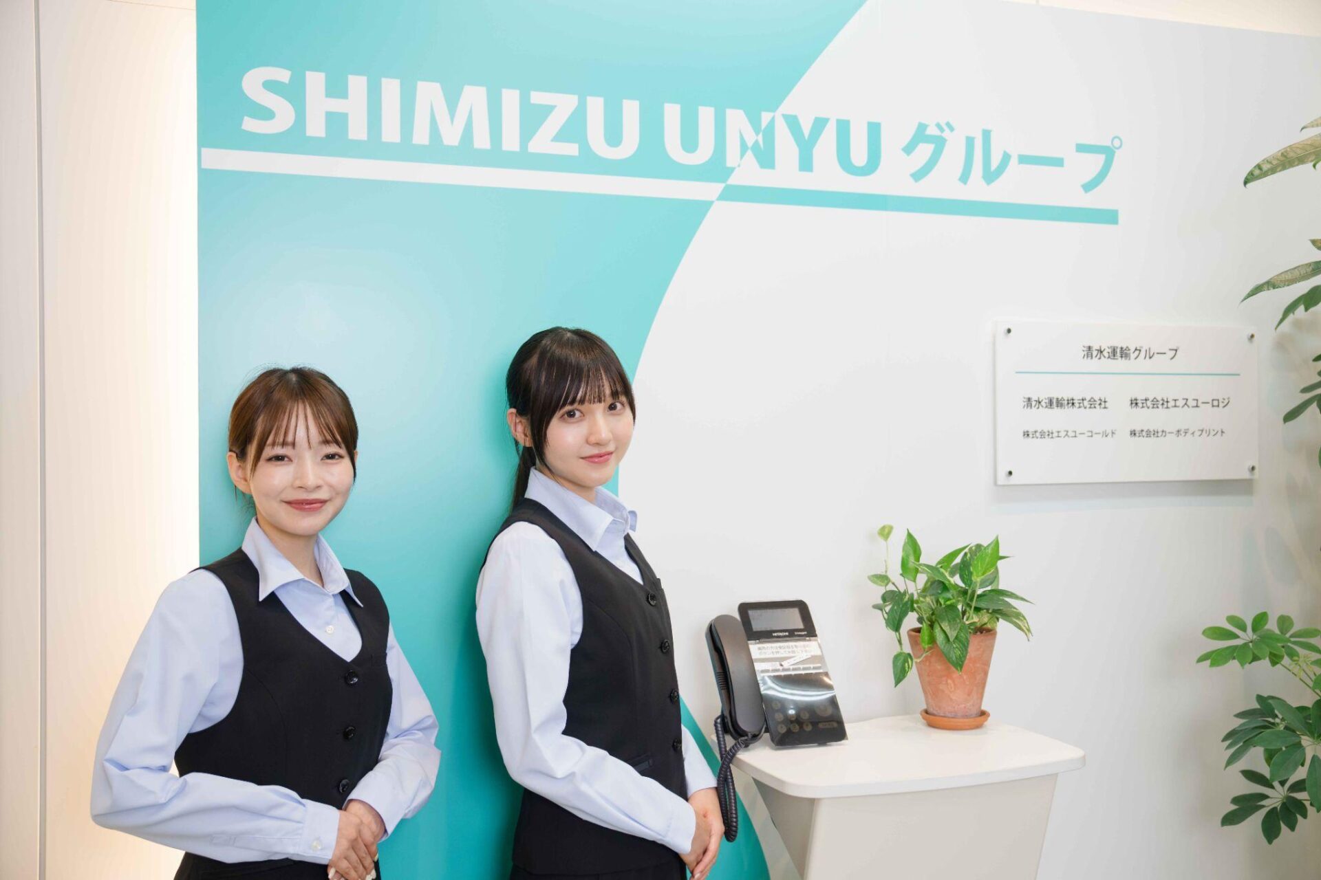 受付スタッフとロゴ