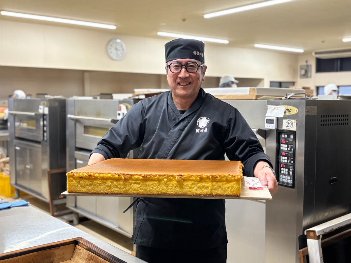 焼き上がった五三焼カステラを持つ伊藤社長